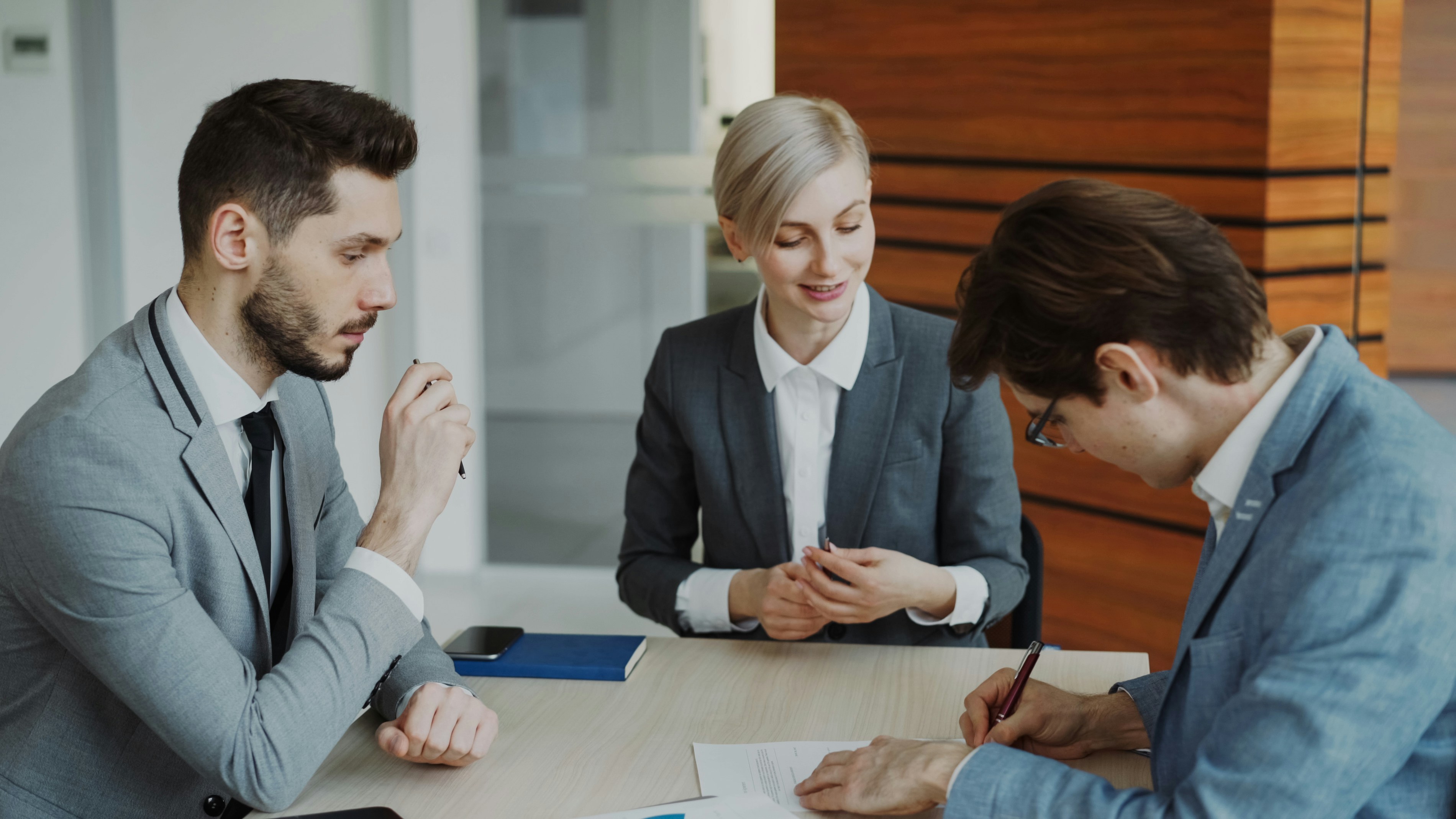 Personas de negocios revisando un contrato en una mesa para diseño web legal en New Jersey