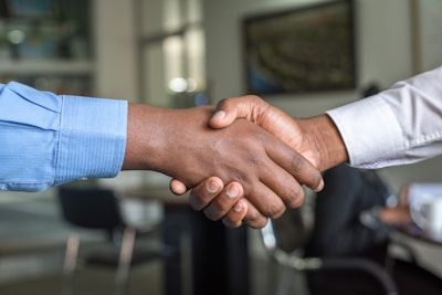 Dos profesionales de negocios dándose la mano en acuerdo comercial - cómo contratar agencia de marketing digital